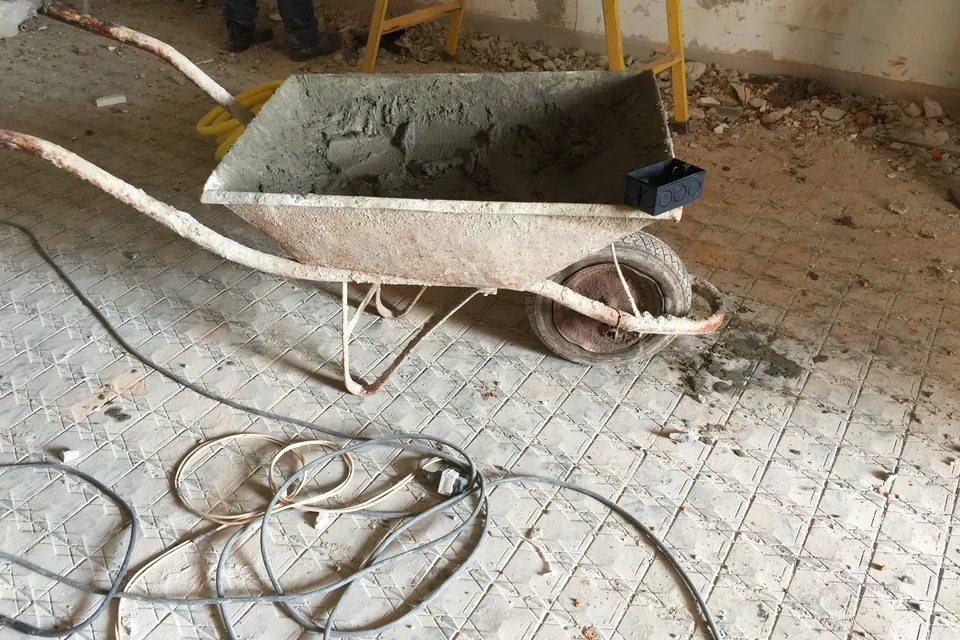 Carrinho de mão com argamassa apoiado sobre as placas de proteção