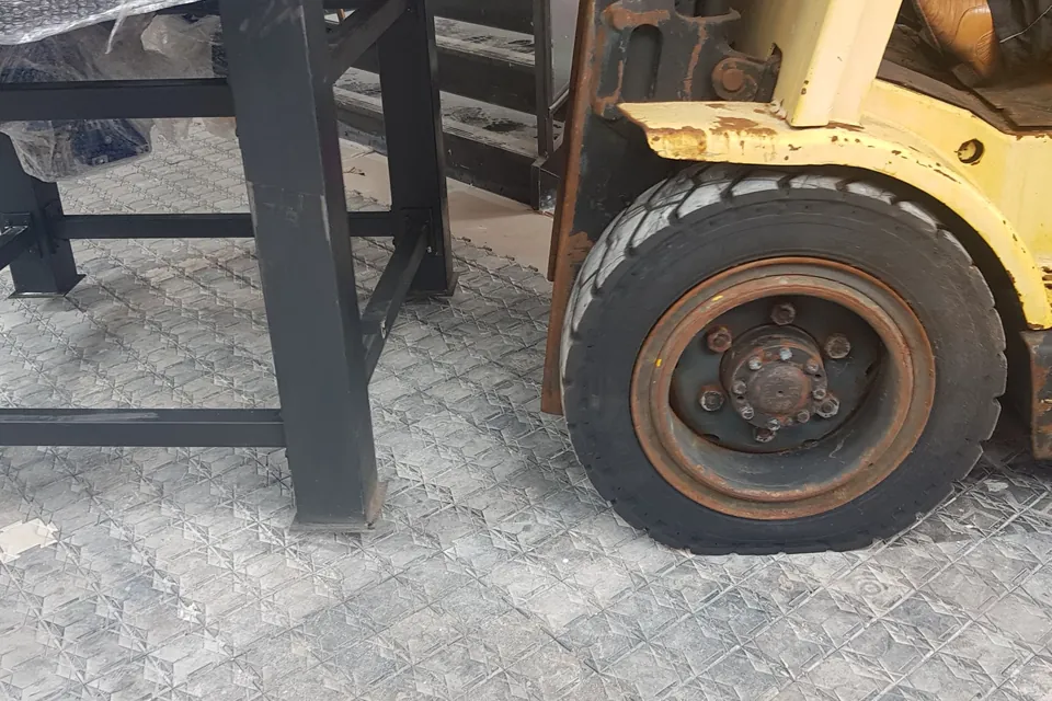 Roda de uma empilhadeira parada sobre as placas de proteção